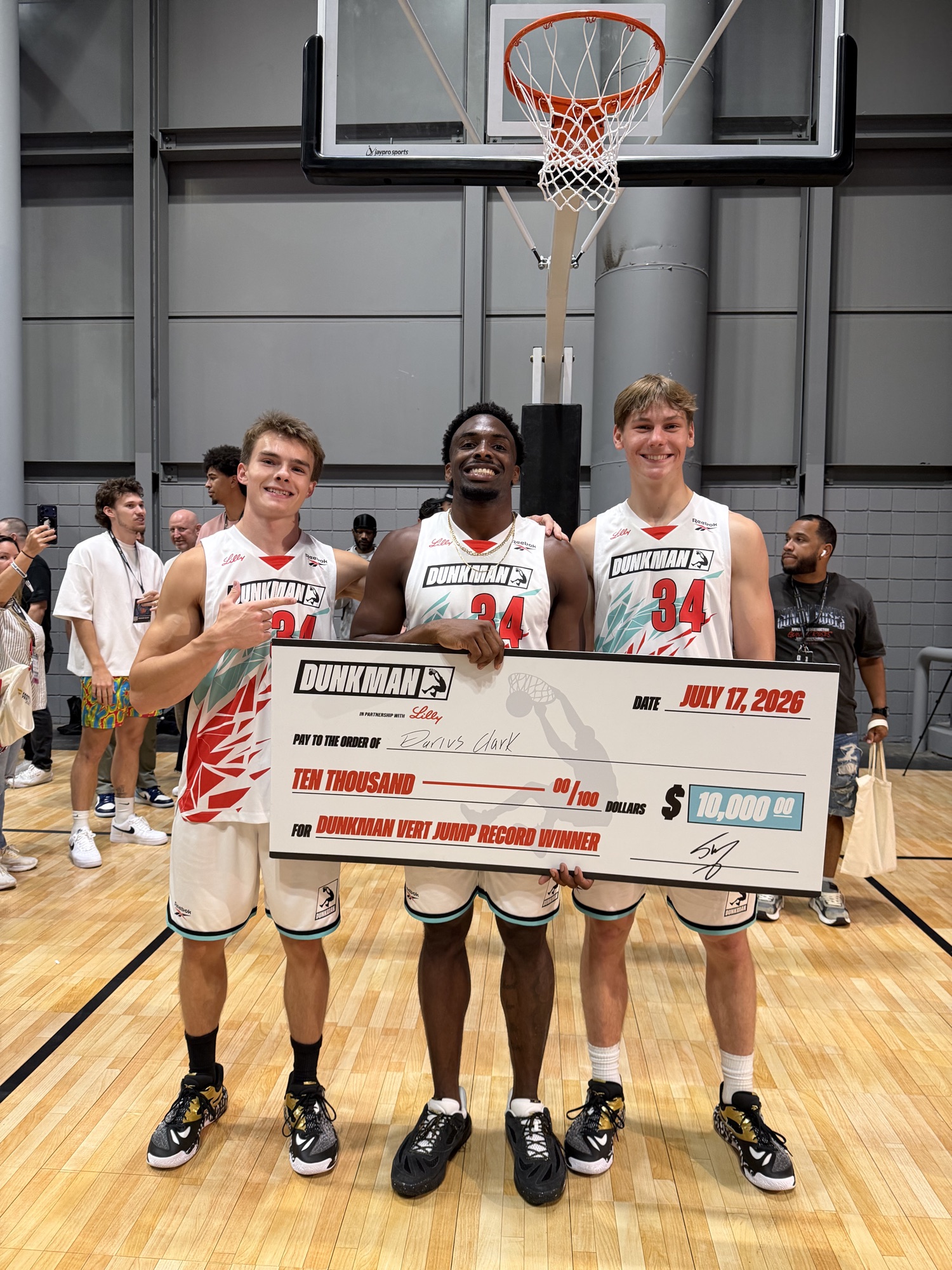 Cam Hazzard with DUNKMAN athletes holding the $10,000 Vert Jump Record check at Fanatics Fest NYC