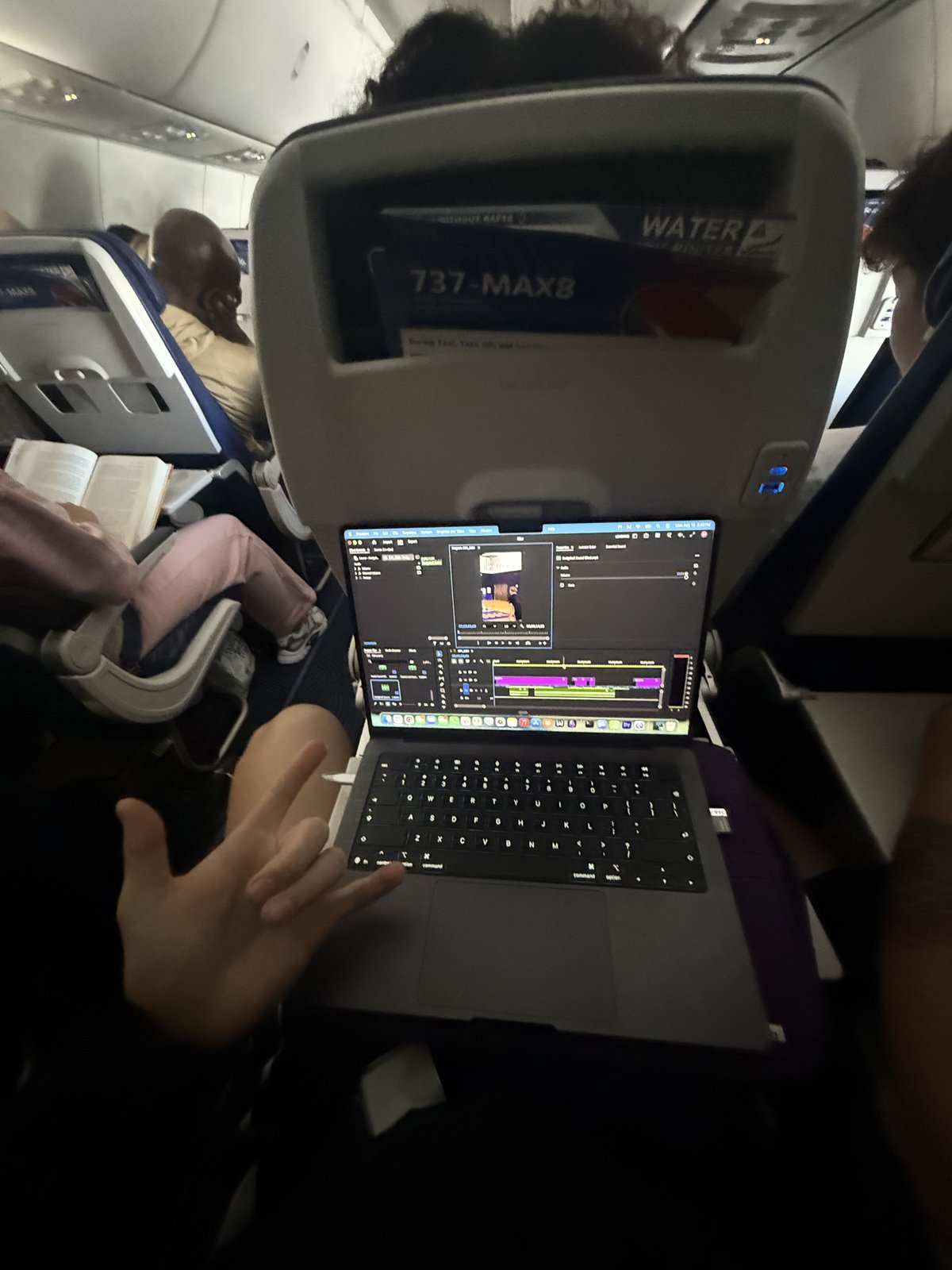 Cam Hazzard editing video on his laptop during the flight